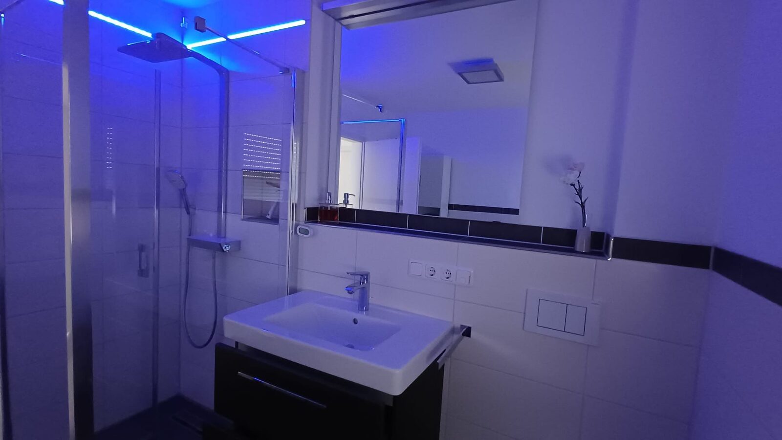 Modernes Badezimmer mit LED-beleuchteter Regenwalddusche in Seeg